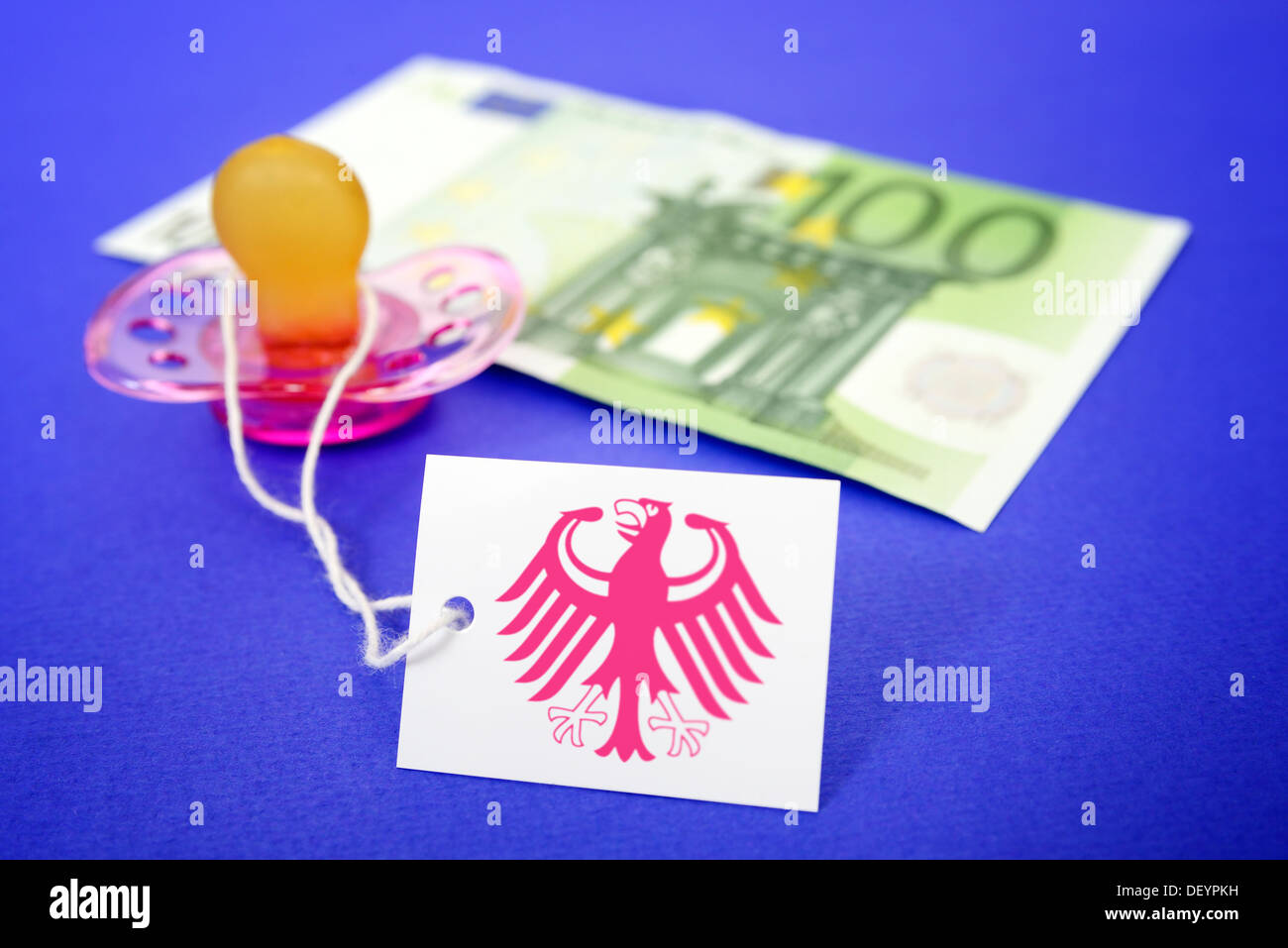 Dummy with euro hundred and label with pink-coloured federal eagle, symbolic photo care money, Schnuller mit Hundert-Euro-Schein Stock Photo