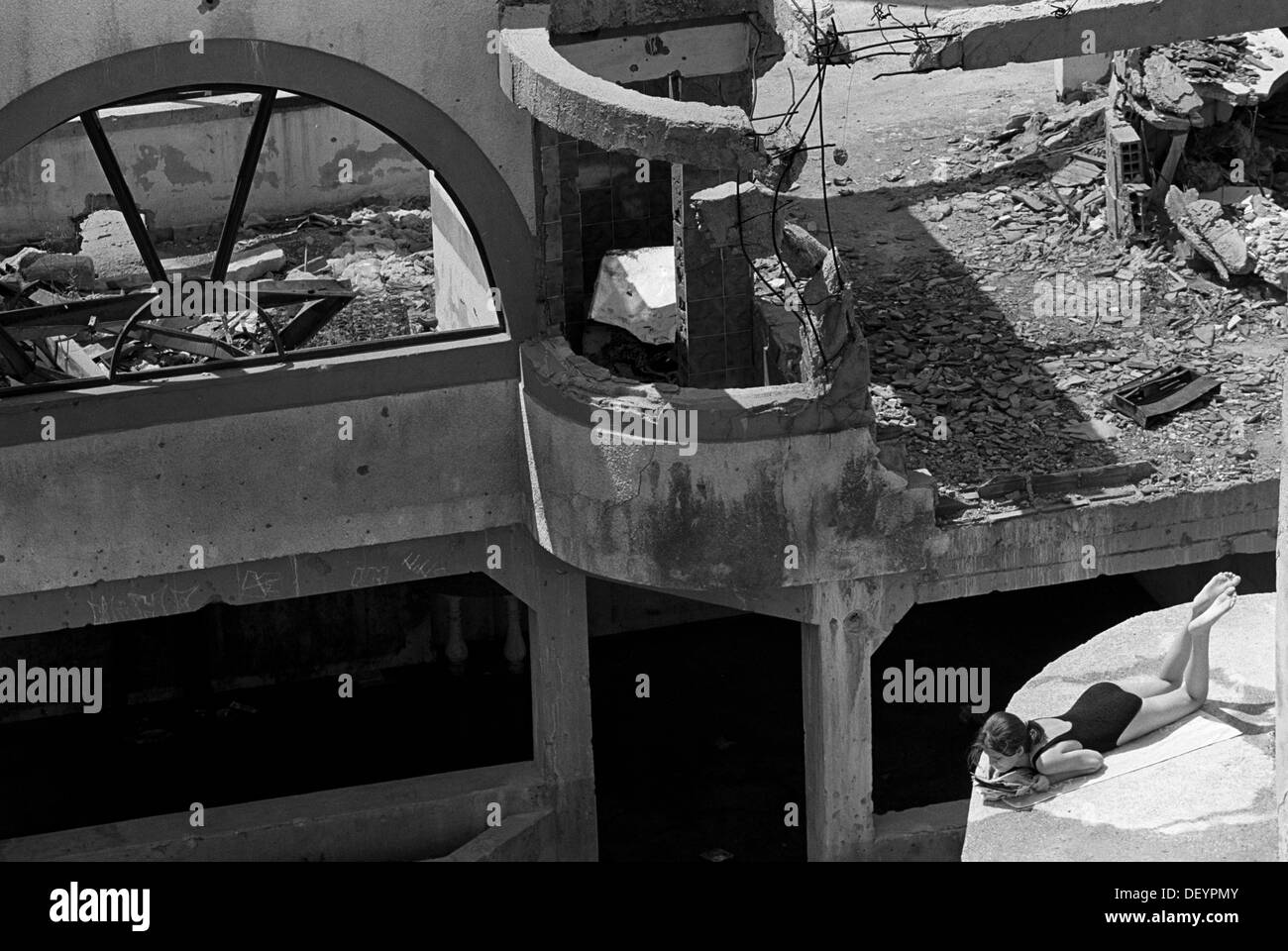 Girl sunbathing in the ruins of muslim East Mostar destroyed in the war with the Croats. Bosnia 1996 Stock Photo