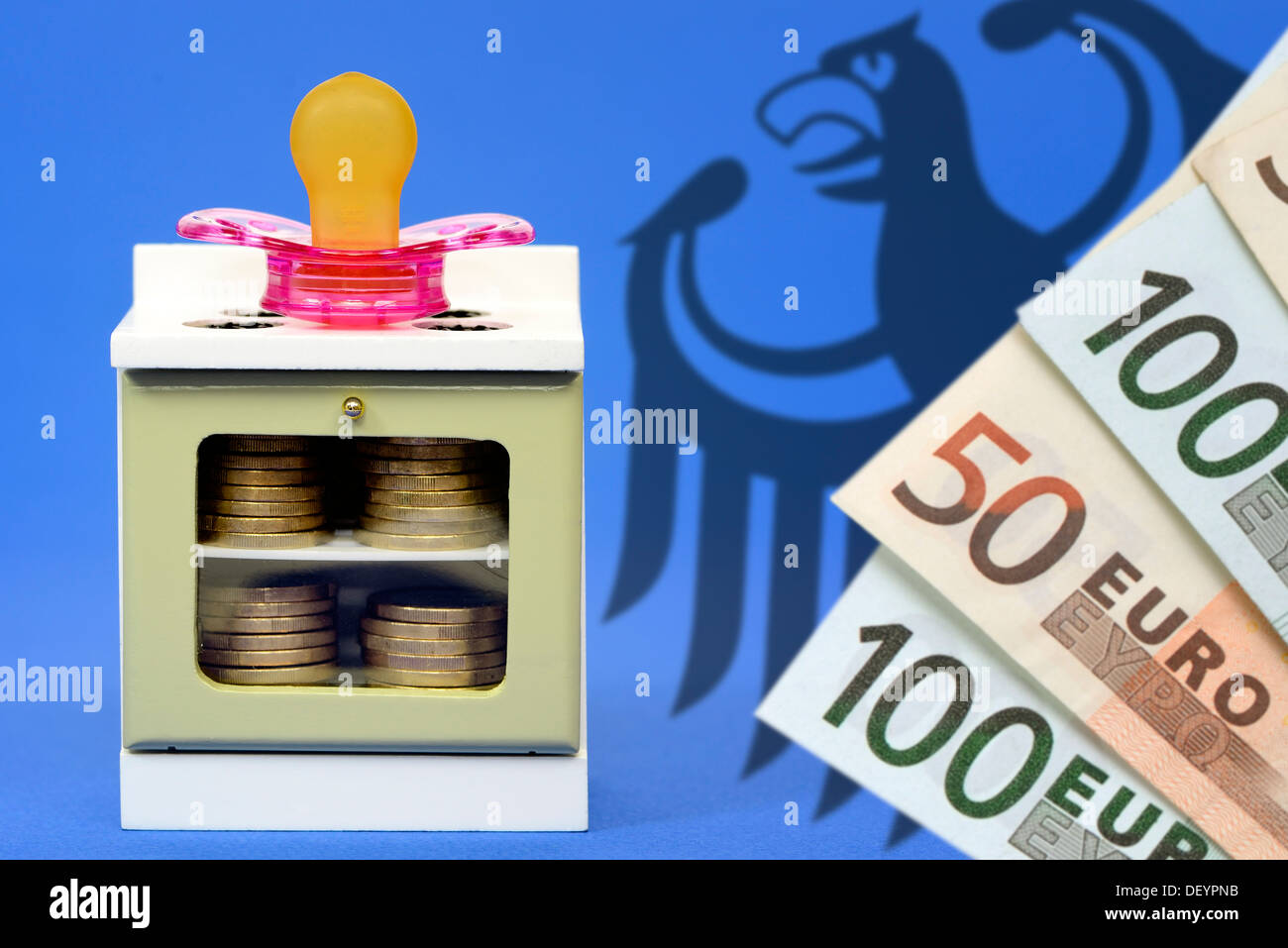 Miniature cooker with dummy and federal eagle, care money, Miniaturherd mit Schnuller und Bundesadler, Betreuungsgeld Stock Photo