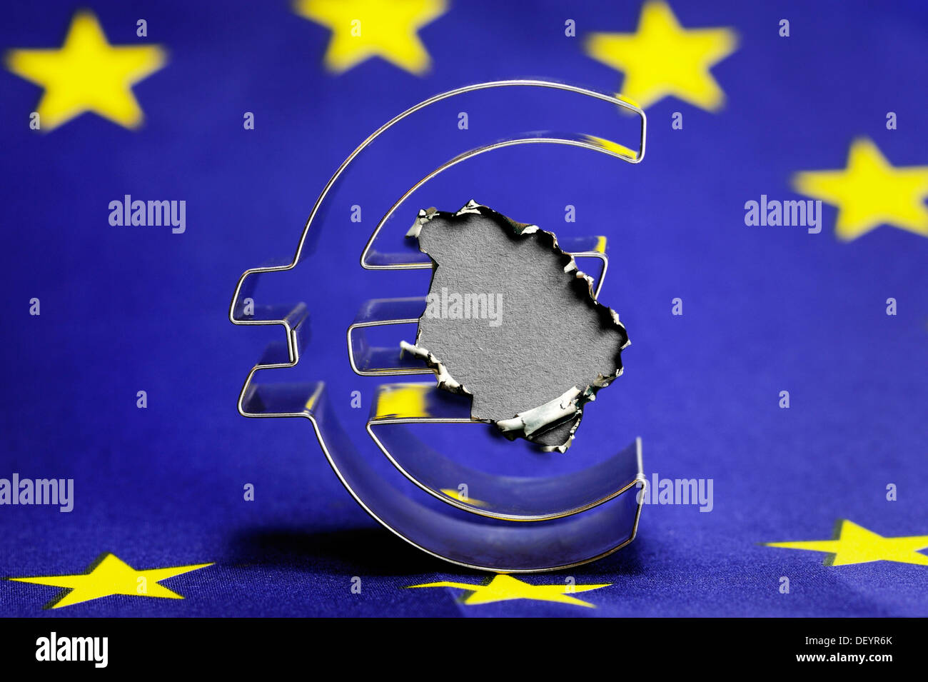 Euro symbol on the EU flag with a burn mark, symbolic image of the euro crisis Stock Photo