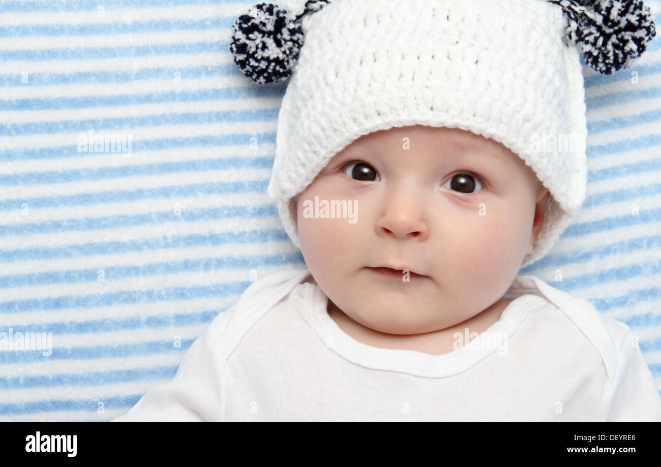 smiling baby lies on back on bed Stock Photo