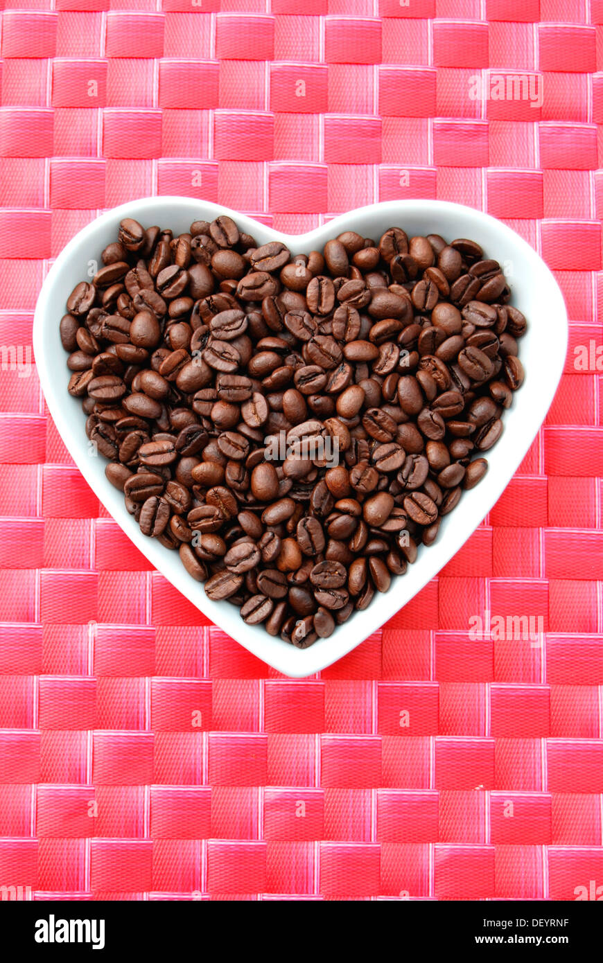 Coffee beans in a heart-shaped porcelain bowl Stock Photo