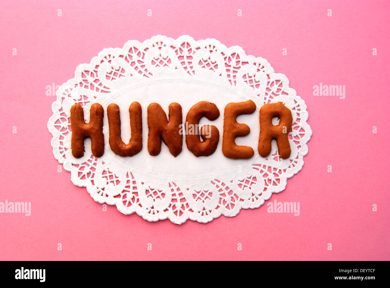 Hunger, lettering, alphabet biscuits on a cake lace coaster Stock Photo ...