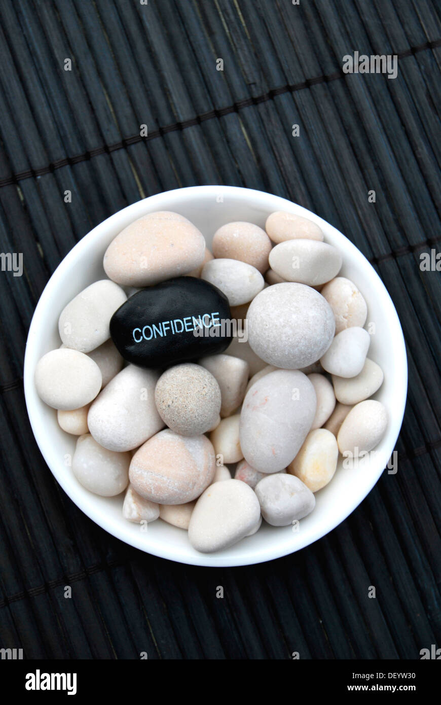 Hot stone massage stones with the inscription Confidence Stock Photo