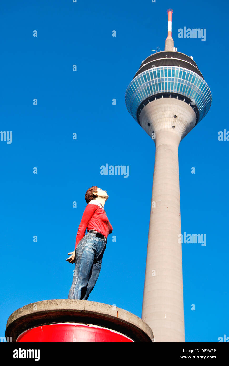 Woman looking up, sculpture on a red pillar pedestal with Rheinturm tower at back, Duesseldorf, North Rhine-Westphalia Stock Photo