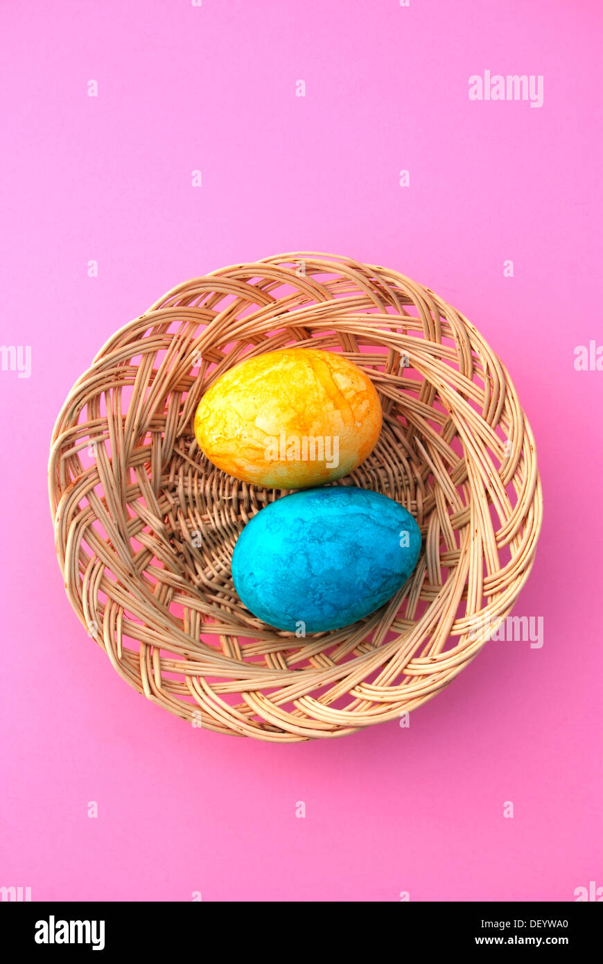 Two colorful Easter eggs in wicker basket Stock Photo