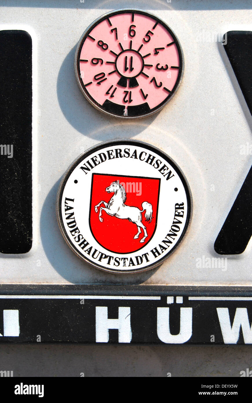 TUEV or vehicle inspection sticker and sticker of Lower Saxony on a number plate, state capitol Hannover Stock Photo