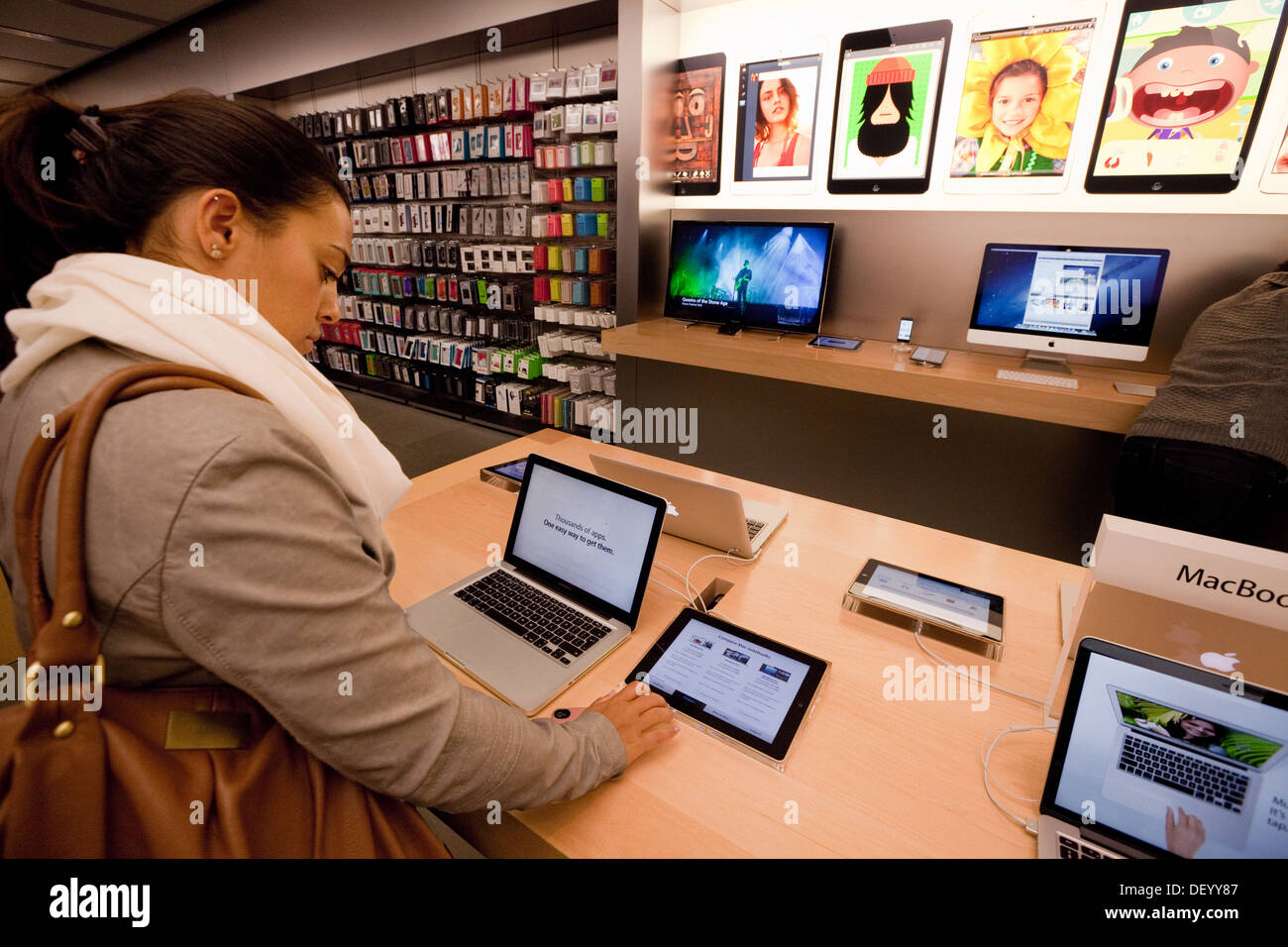 Teenage girl student shopping for an Apple Macbook laptop computer in the Apple Store, Grand Arcade Cambridge UK Stock Photo