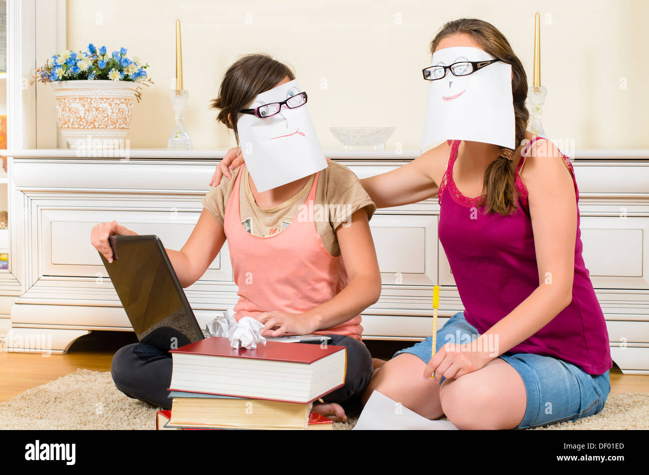 Schoolgirls studying wearing comic masks Stock Photo