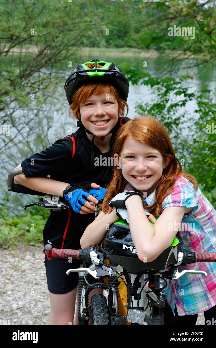 Two children, boy and girl, with mountain bikes and helmets Stock Photo