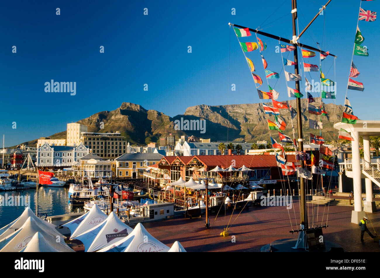 Colourful flags, boats, outdoor cafes, Table Mountain, Victoria & Alfred Waterfront, Cape Town, Western Cape, South Africa Stock Photo