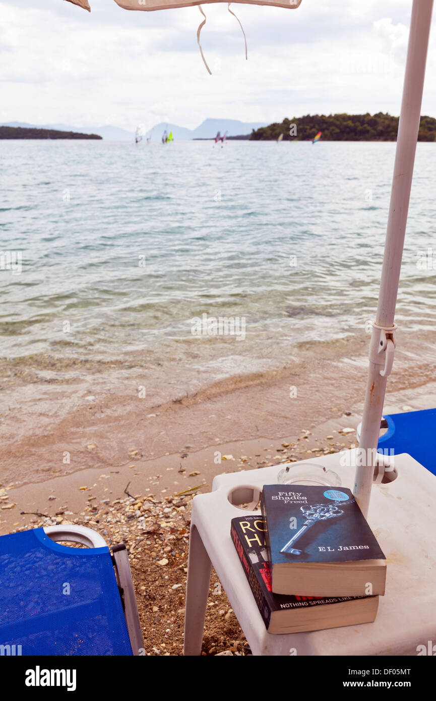 fifty shades of grey reading book on holiday beach sea coast Nidri Nydri Lefkada Lefkas Greek Island Greece Stock Photo