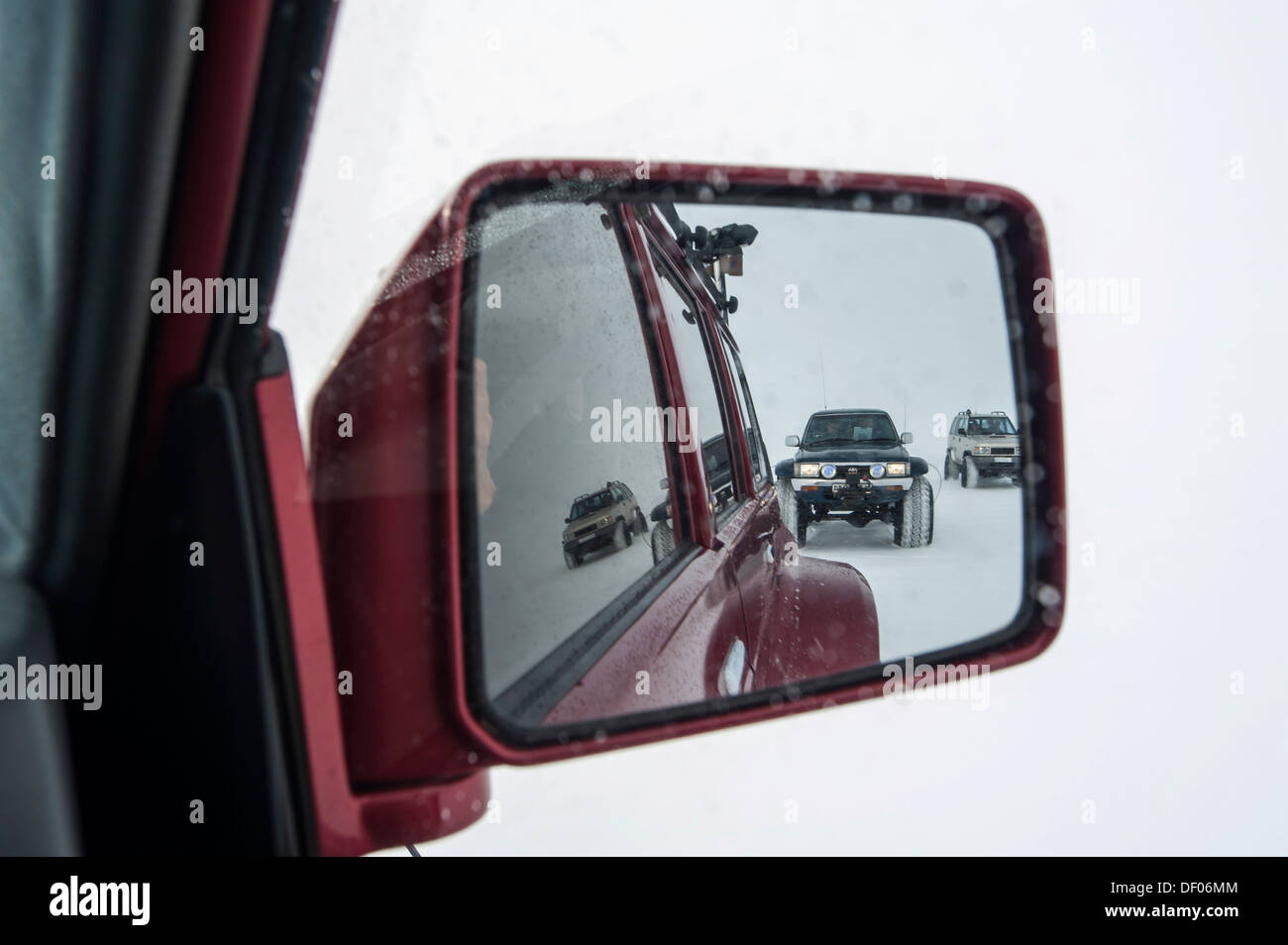 Super Jeep in a winter landscape, view in the rearview mirror