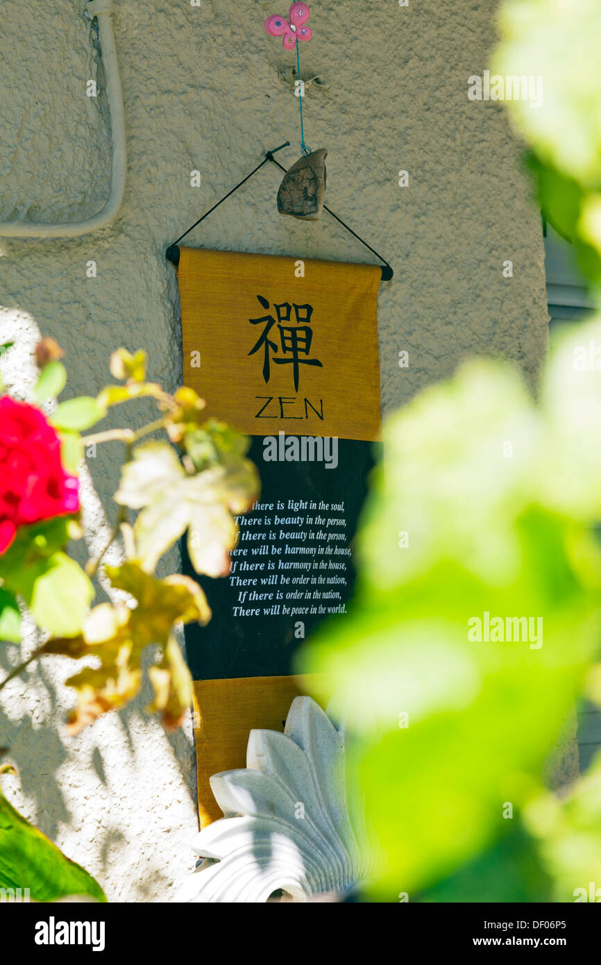 Zen meaning on sign on wall through flowers Nidri Nydri Lefkada Lefkas