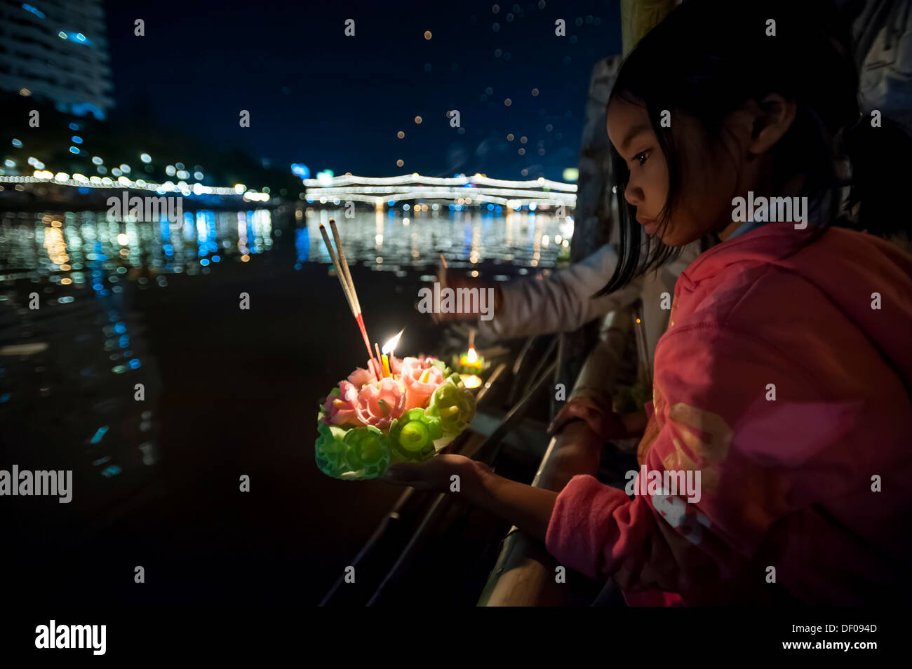 Young girl placing a ceremonial raft in the river, Loi or Loy Krathong Festival, Chiang Mai, Northern Thailand, Thailand, Asia Stock Photo