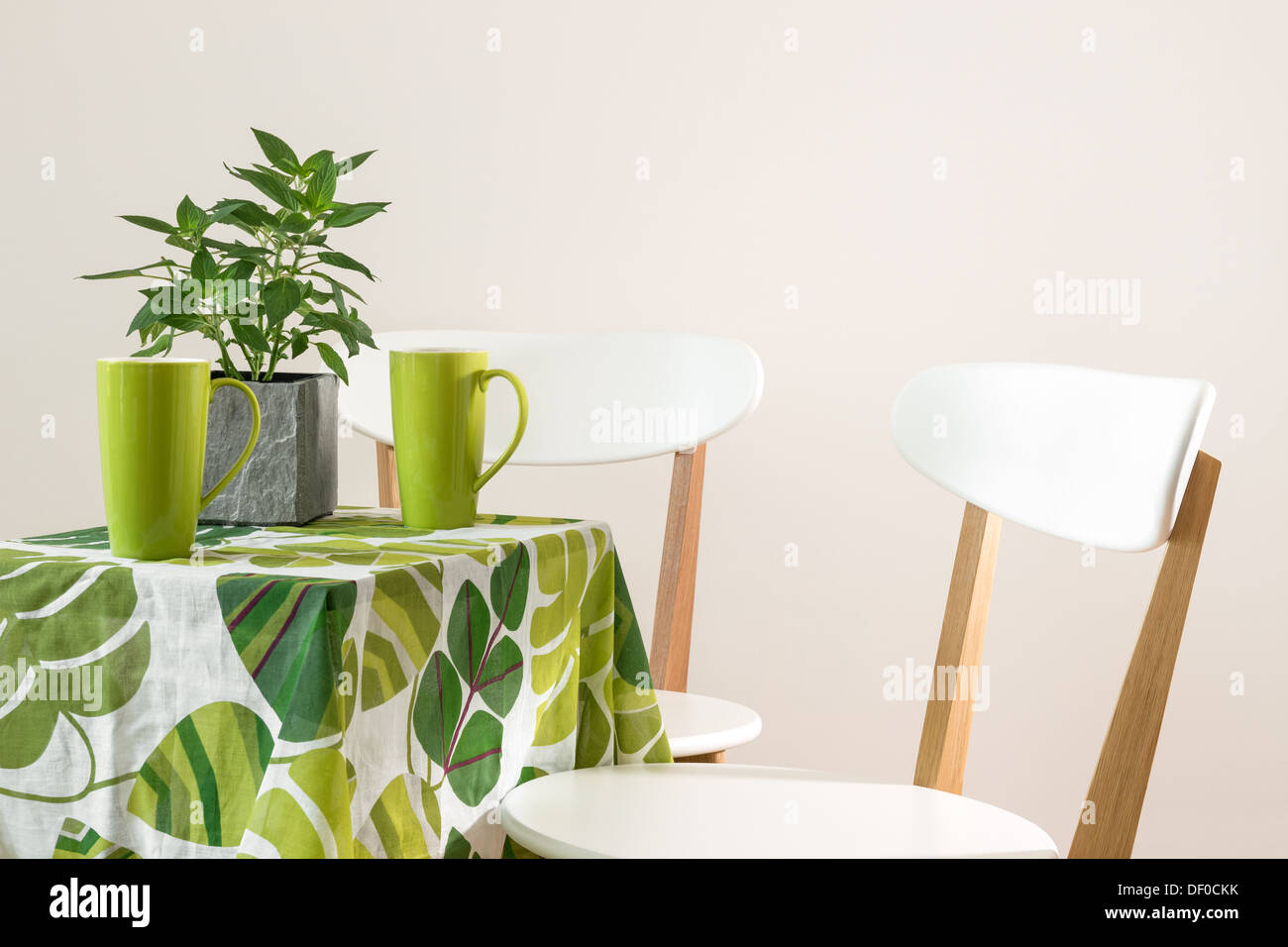 Two Chairs And Bright Table With Teacups And Mint In A Pot