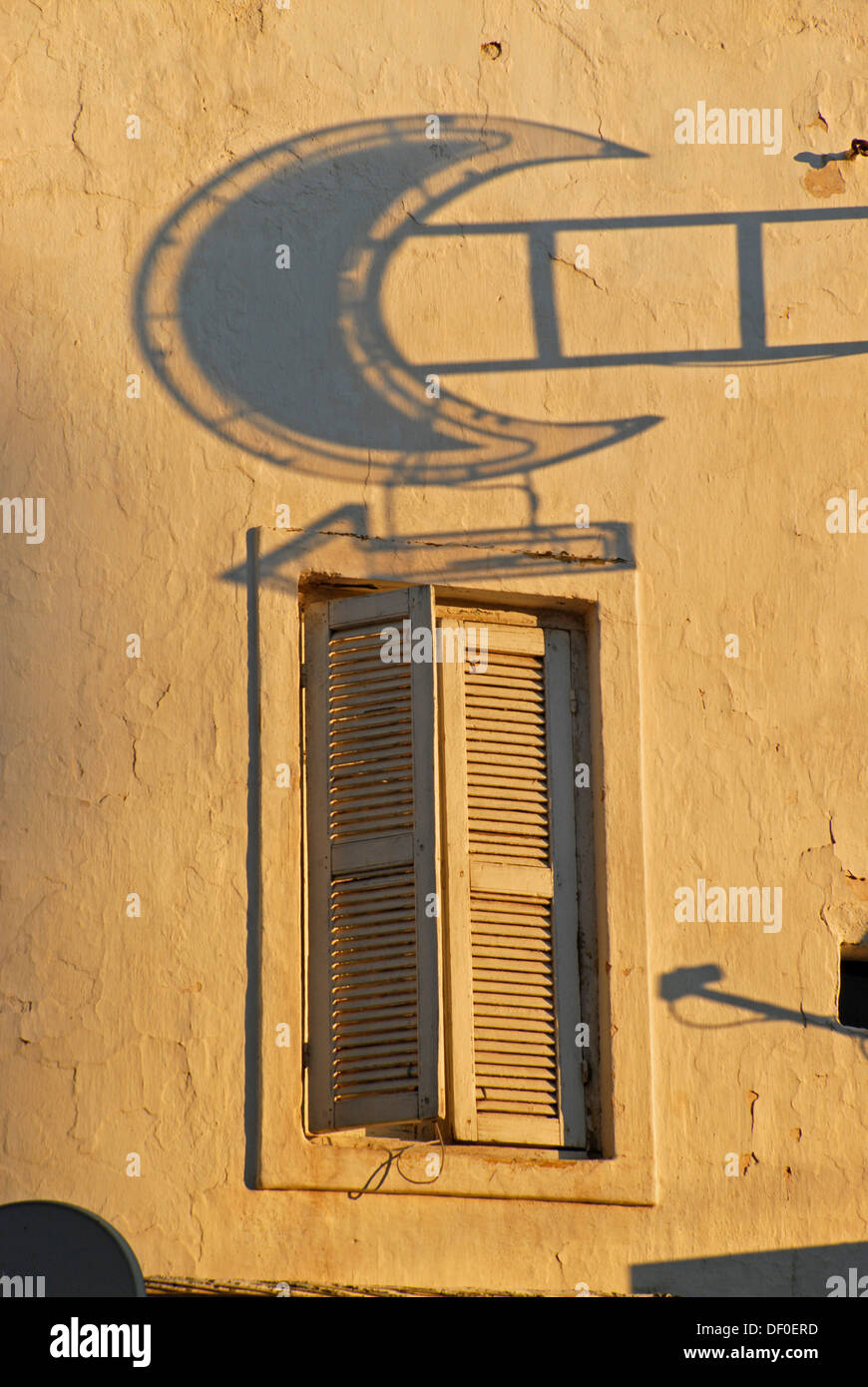 The shadow of the sign of a pharmacy and a window illuminated by warm morning light, Rabat, Morocco, Africa Stock Photo