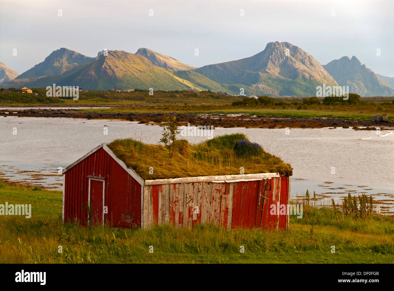 A hut with a grass roof in front of the peaks of the island of Langøya, Langoya, part of the Vesterålen Stock Photo