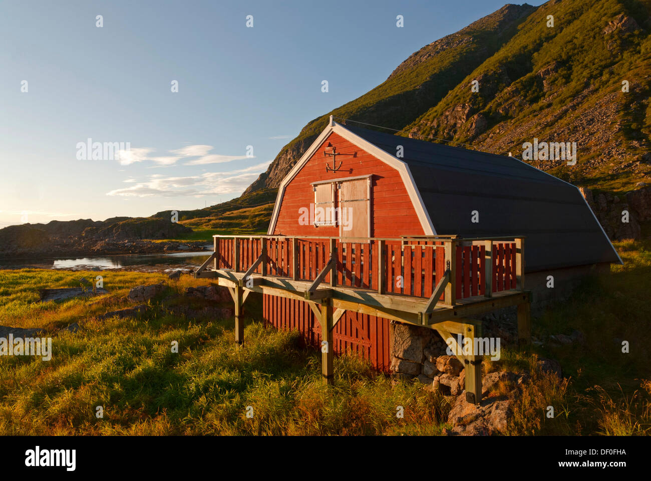 Typical red Rorbuer huts, rorbu, illuminated by warm evening light near Straume on the island of Langøya, Langoya Stock Photo