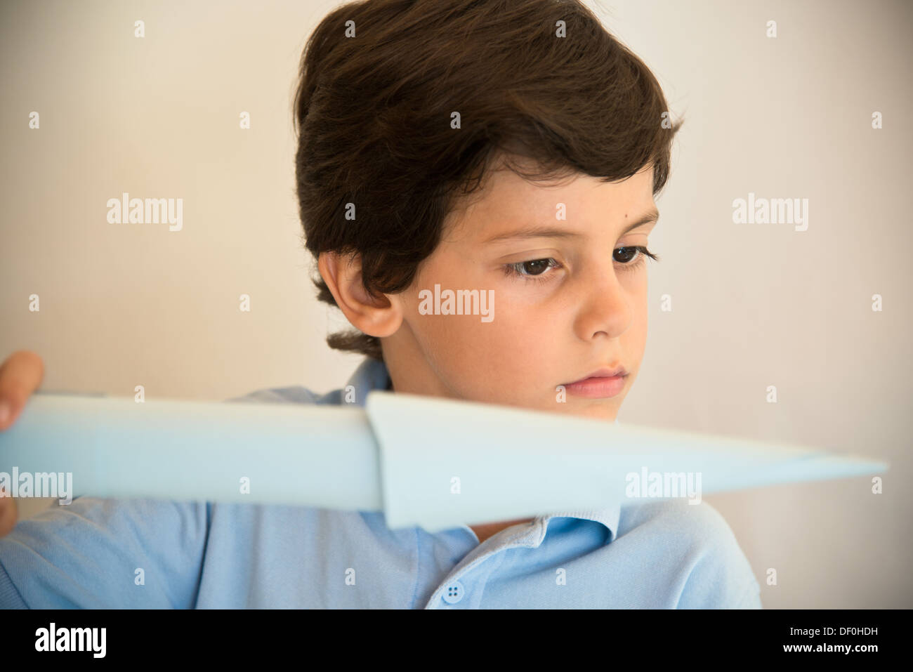 Boy flying light blue paper airplane Stock Photo