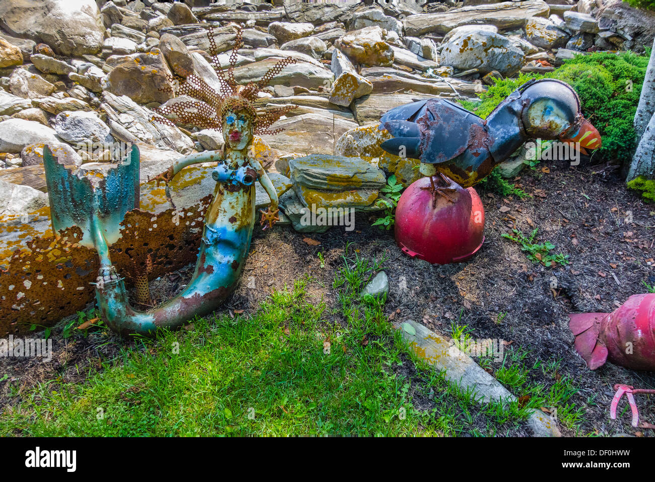 Folk art metal mermaid and duck on display in the front lawn of a Maine house by the seashore. Stock Photo