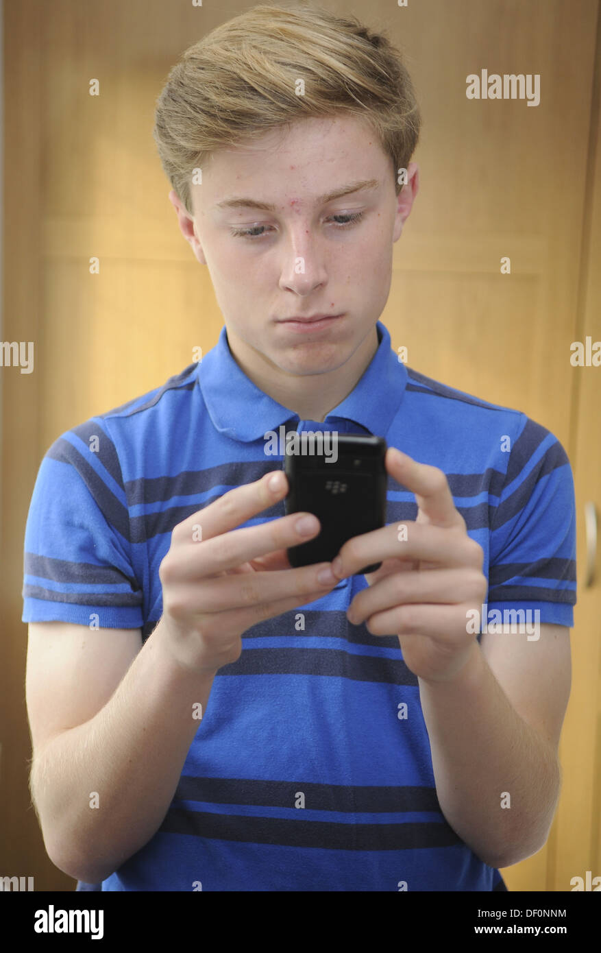 Teenage Boy Using A Mobile Phone Stock Photo