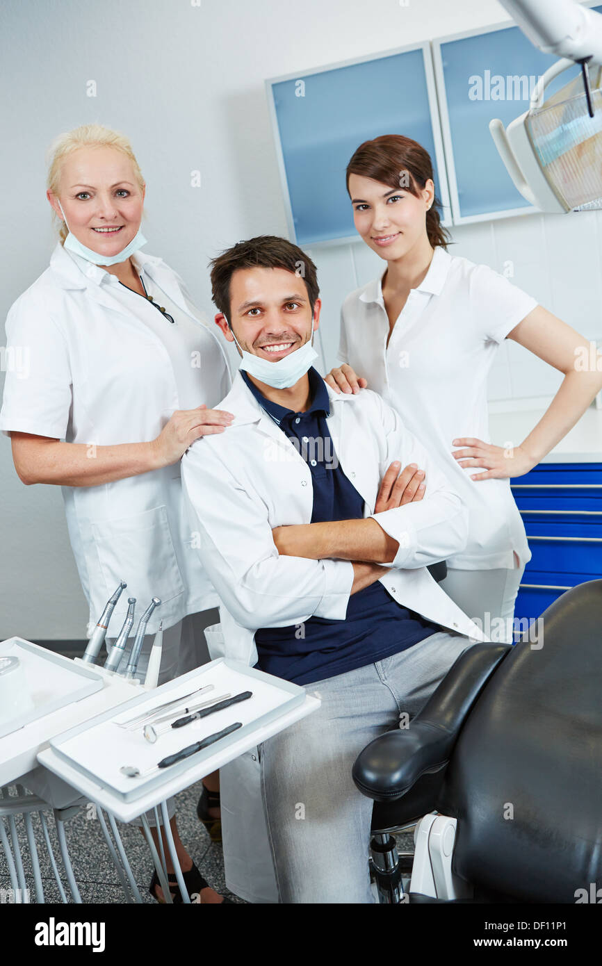 Dentist with group of dental assistants in his dental practice Stock Photo