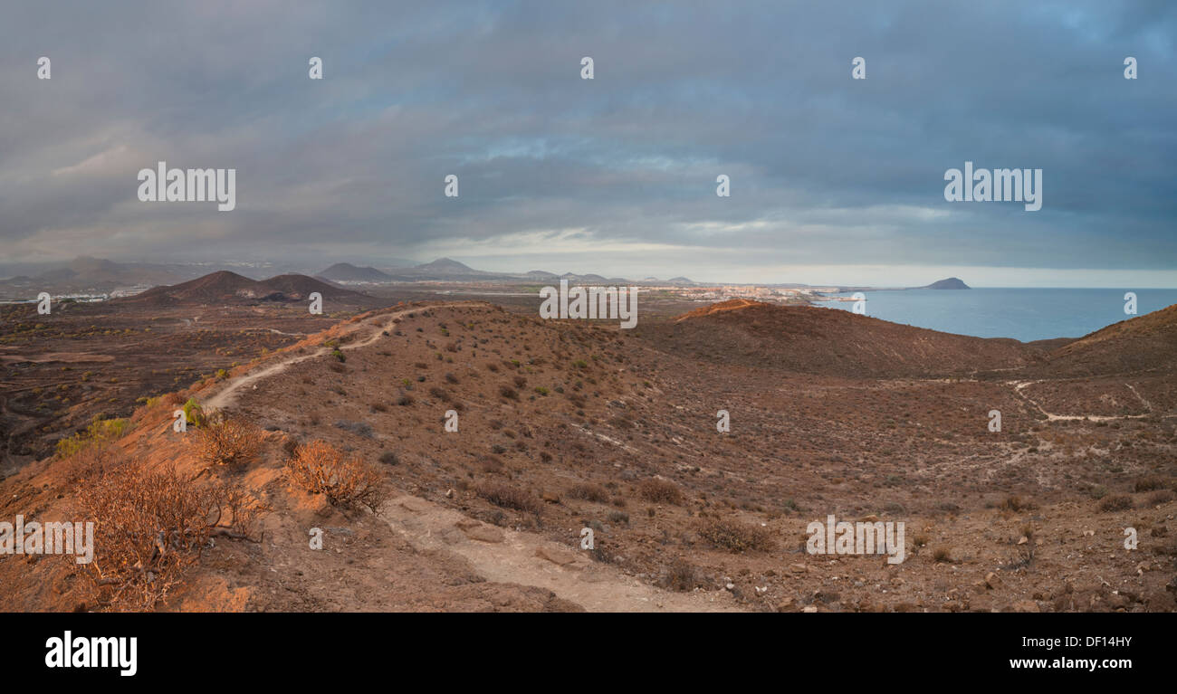 Path across the rim of Montana Amarilla, an old volcanic cone near Costa del Silenciio, Tenerife, looking towards El Medano Stock Photo