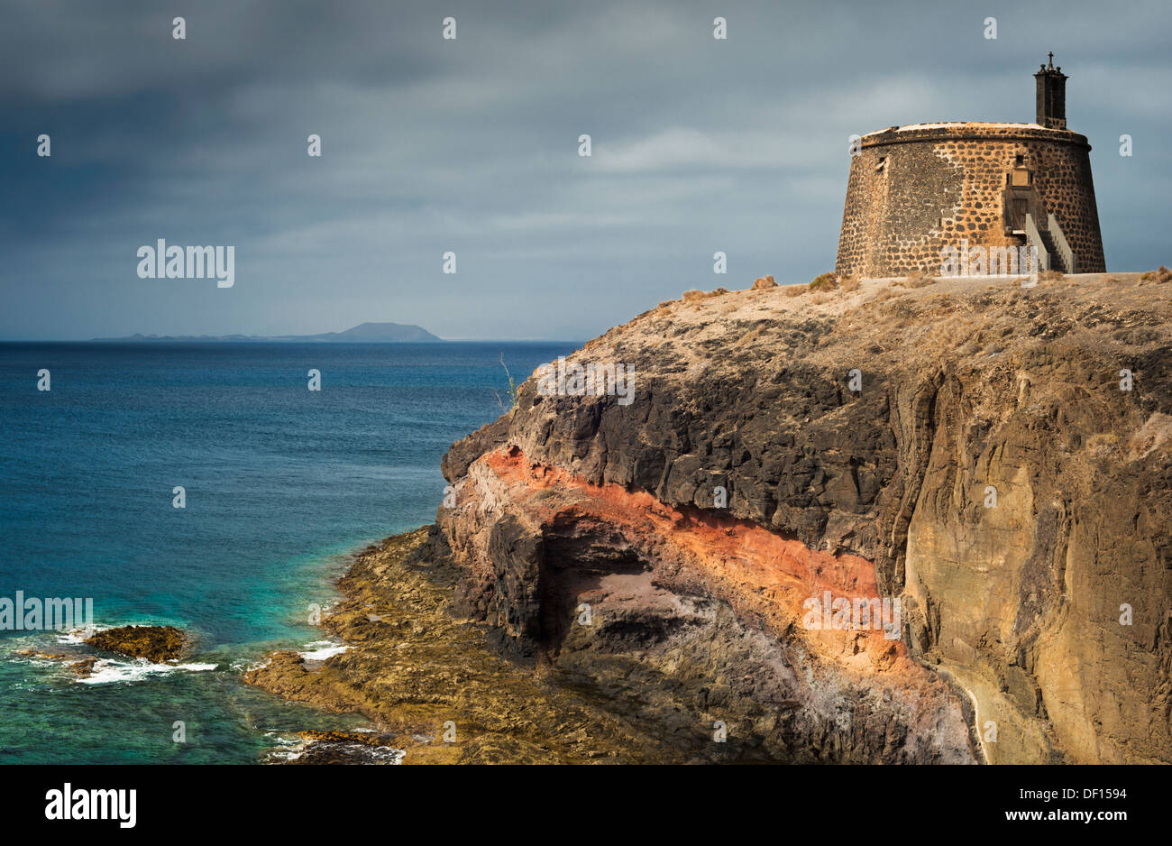 Castillo de las Coloradas on the cliffs east of Playa Blanca, Lanzarote, with the island of Fuerteventura in the distance Stock Photo