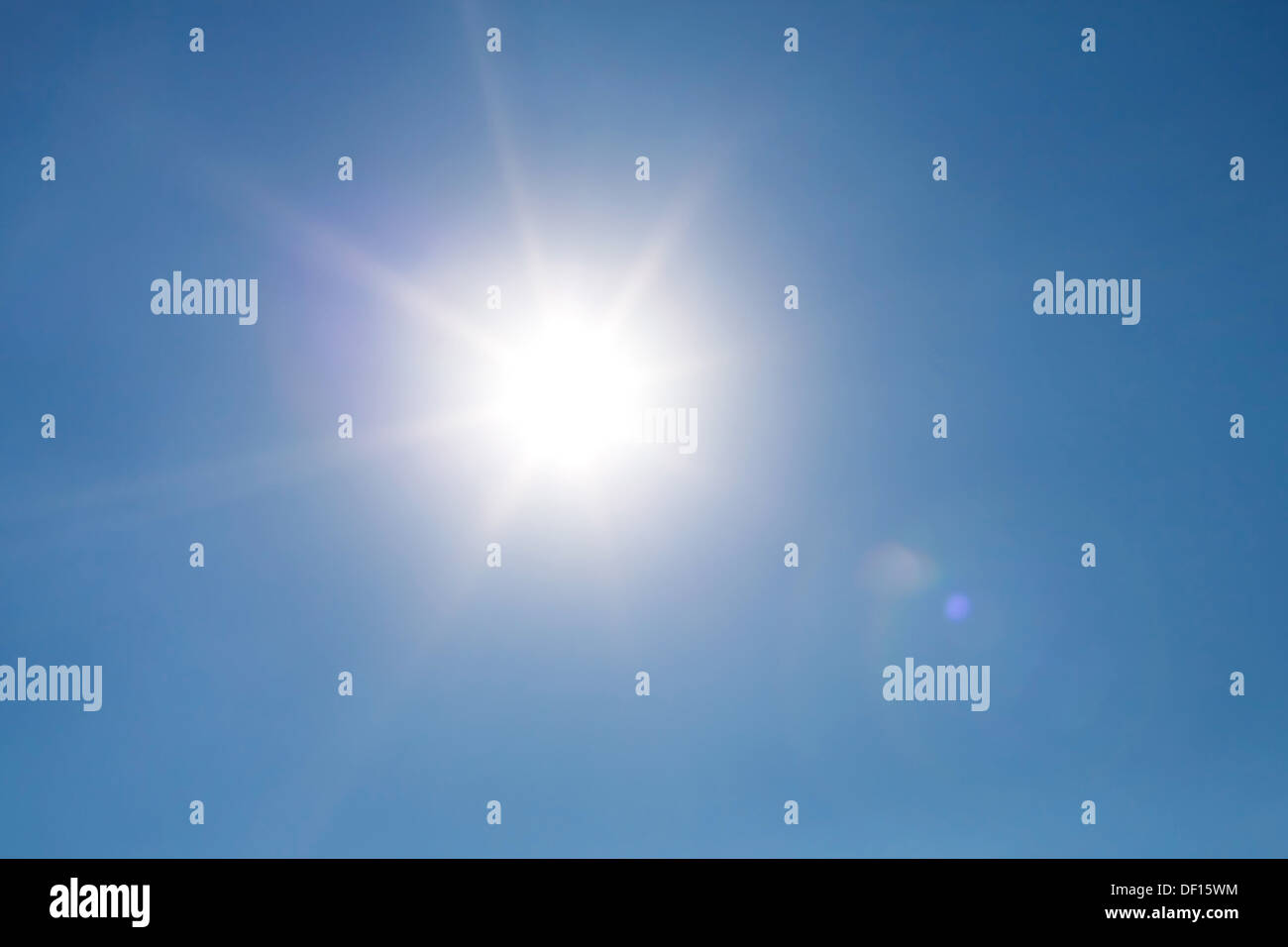 Real photo lens glow effect of sun on clear blue sky Stock Photo