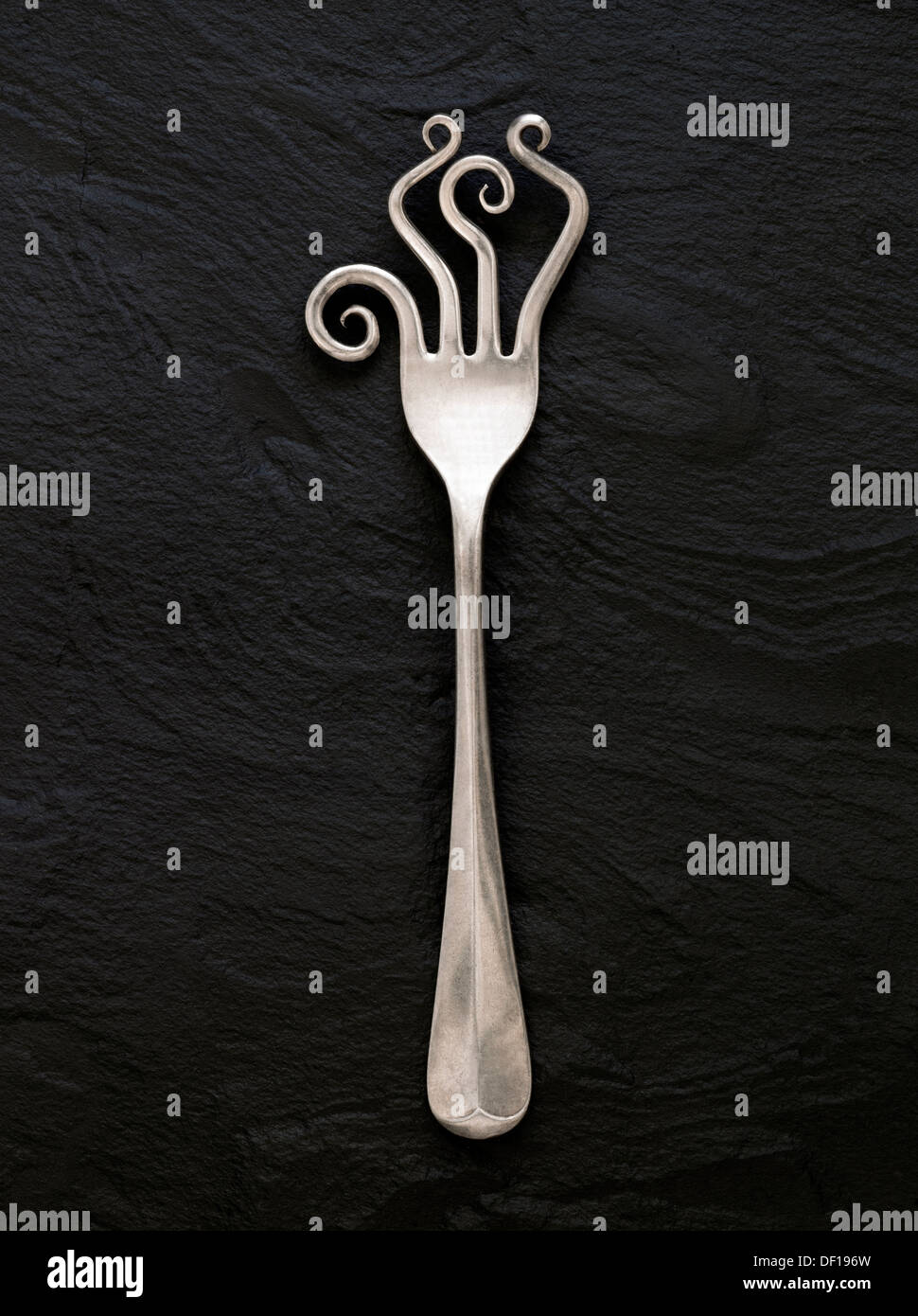 Close up of old vintage kitchen fork with wild curly prongs or tines Stock Photo