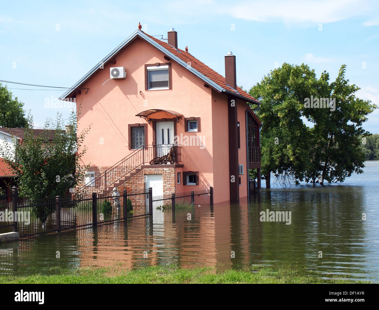 big flooded house with blue sky and white clouds in high water Stock Photo