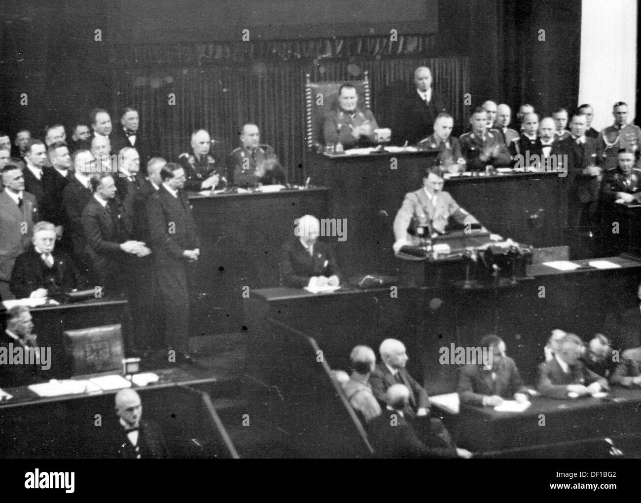 The image from the Nazi Propaganda! shows Reich Chancellor Adolf Hitler delivering a speech to the Reichstag in the Kroll Opera House in Berlin, Germany, 17 May 1933. To the left, first row: Vice Chancellor Franz von Papen; second row Minister of Economics and Agriculture Alfred Hugenberg. Behind Hitler, Hermann Göring. Fotoarchiv für Zeitgeschichte Stock Photo