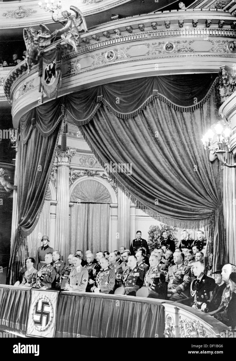 The image from the Nazi Propaganda! shows Adolf Hitler in the luxury suite of the Berlin State Opera at Unter den Linden in Berlin, Germany, on the occasion of the Heldengedenktag (Day of Commemoration of Heroes) on 12 March 1939. First row (l-r): Reich Propaganda Minister Joseph Goebbels, Field Marshal Wilhelm Keitel, Hitler, Commander-in-Chief of the Army Walther von Brauchitsch,  General of the Luftwaffe Hans-Jürgen Stumpff, General Fedor von Bock. Behind Bock, Head of the National Socialist War Victim's Care Hanns Oberlindober. 4-r SS-Obergruppenführer Reinhard Heydrich. To the right behin Stock Photo