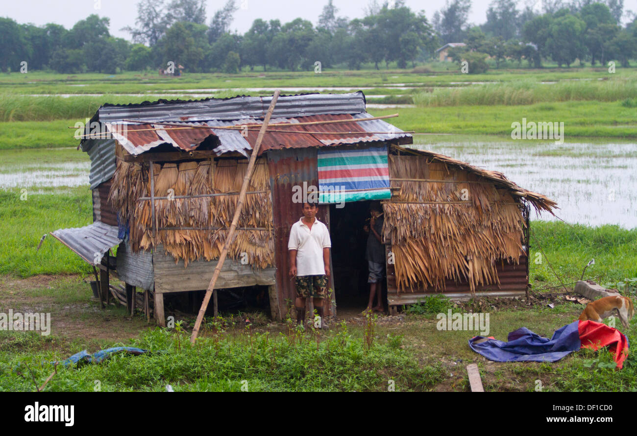A man stands in front of a house outside Kinpun, Burma. Stock Photo