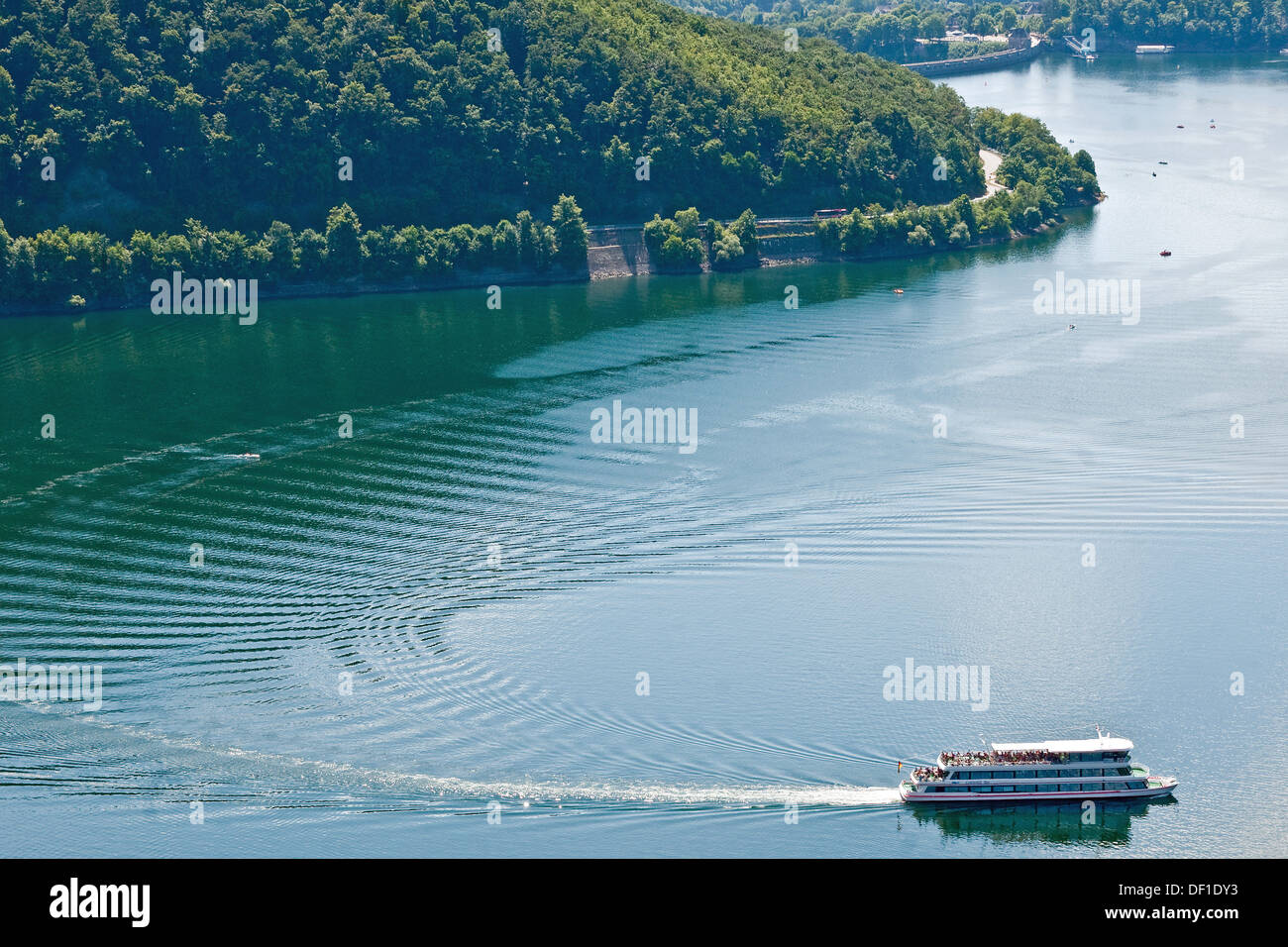 Tourist boat carves a wake on the Eder Lake, Germany. The Eder Dam, breached by the Dambusters on 17 May 1943, is at top right. Stock Photo