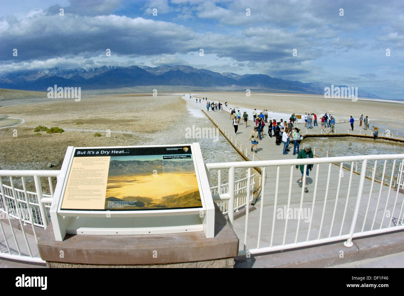 Interpretative sign and tourists on the boardwalk at Badwater (lowest point in the US) under Telescope Peak, Death Valley Stock Photo