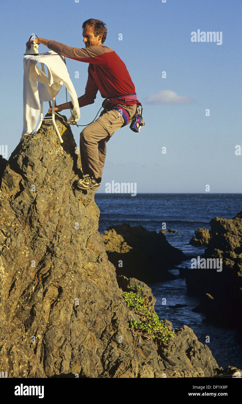 Extreme ironing, ironing a shirt on top of a rock pinnacle Houghton Bay  Wellington New Zealand Stock Photo - Alamy