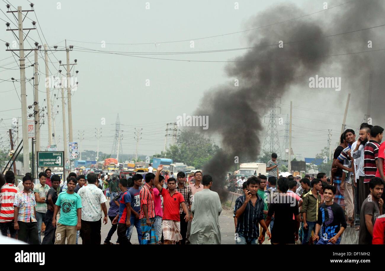 Narayanganj, Bangladesh. 26th Sep, 2013. Bangladeshi garment workers shout slogans during a protest in Narayanganj on September 26, 2013. Most Bangladesh garment factories have reopened after five days of violent protests over wage hikes for textile workers, after the government vowed to crack down on the unrest 'with all force. Stock Photo