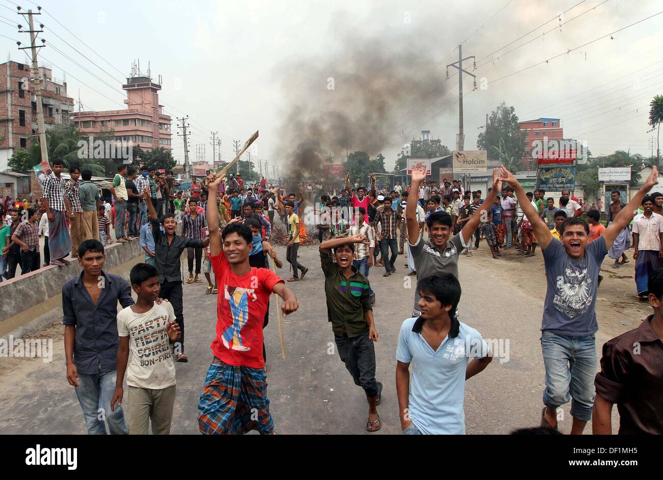 Narayanganj, Bangladesh. 26th Sep, 2013. Bangladeshi garment workers shout slogans during a protest in Narayanganj on September 26, 2013. Most Bangladesh garment factories have reopened after five days of violent protests over wage hikes for textile workers, after the government vowed to crack down on the unrest 'with all force. Stock Photo