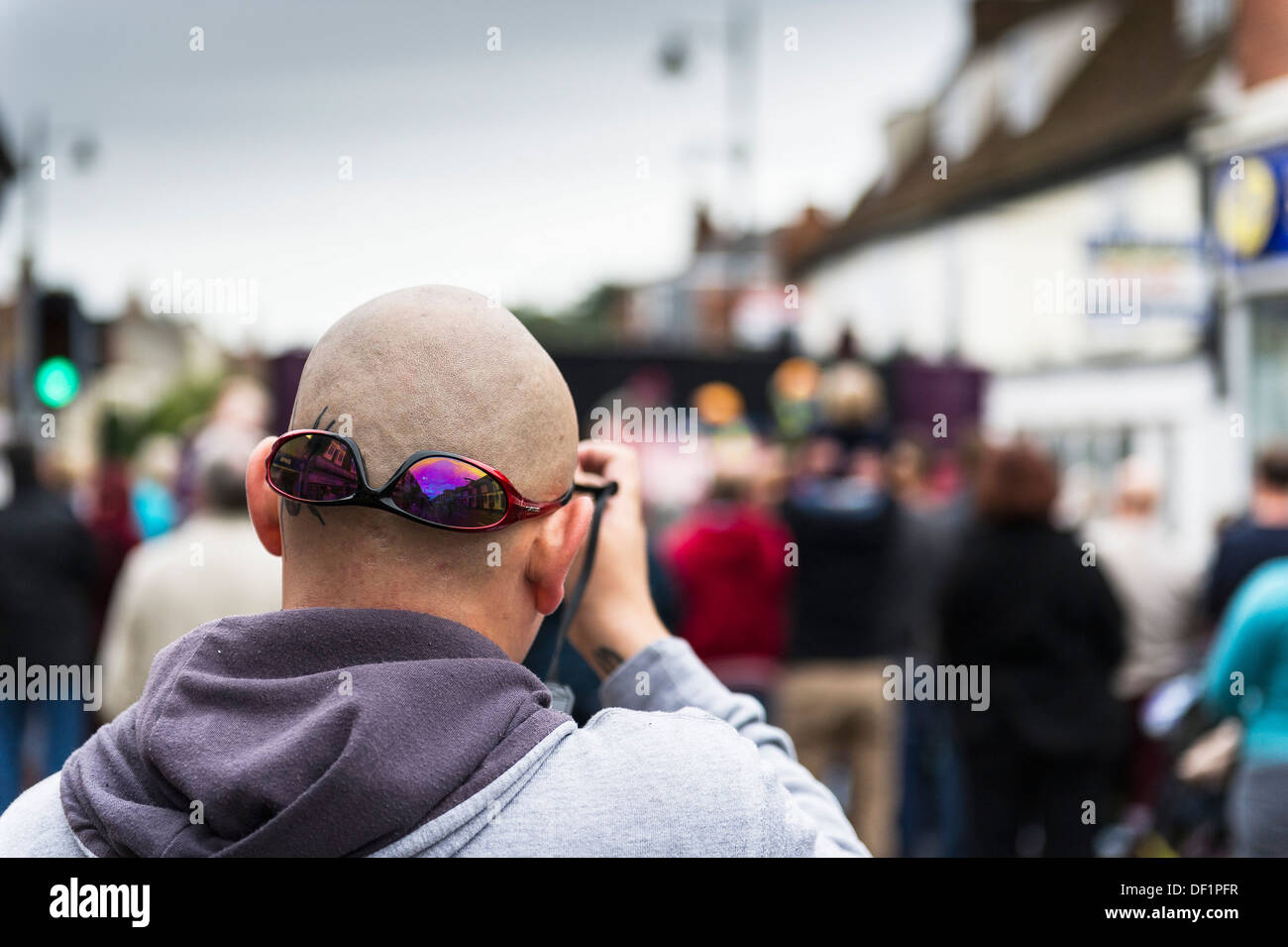 A bald man wearing his sunglasses on the back of his head. Stock Photo