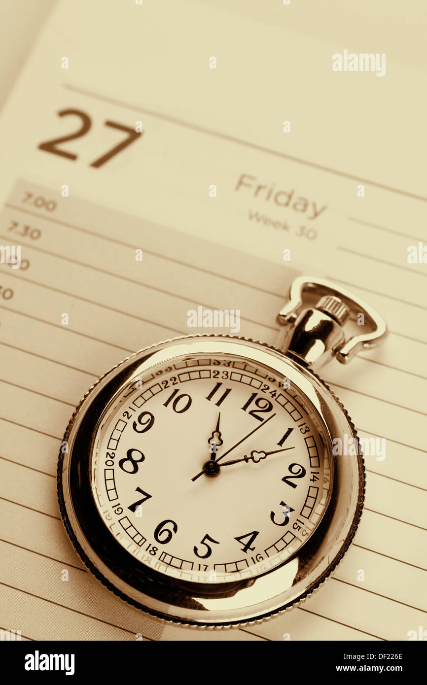 Pocket watch on diary page Stock Photo