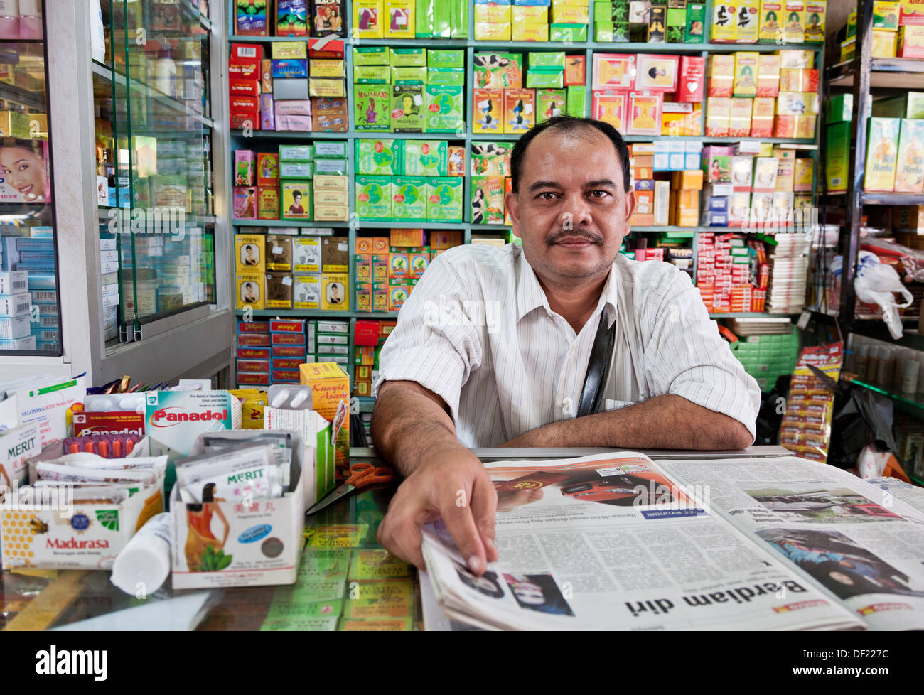 Man with newspaper selling herbs and pharmacy products at Chow Kit Market, Kuala Lumpur Malaysia. Stock Photo