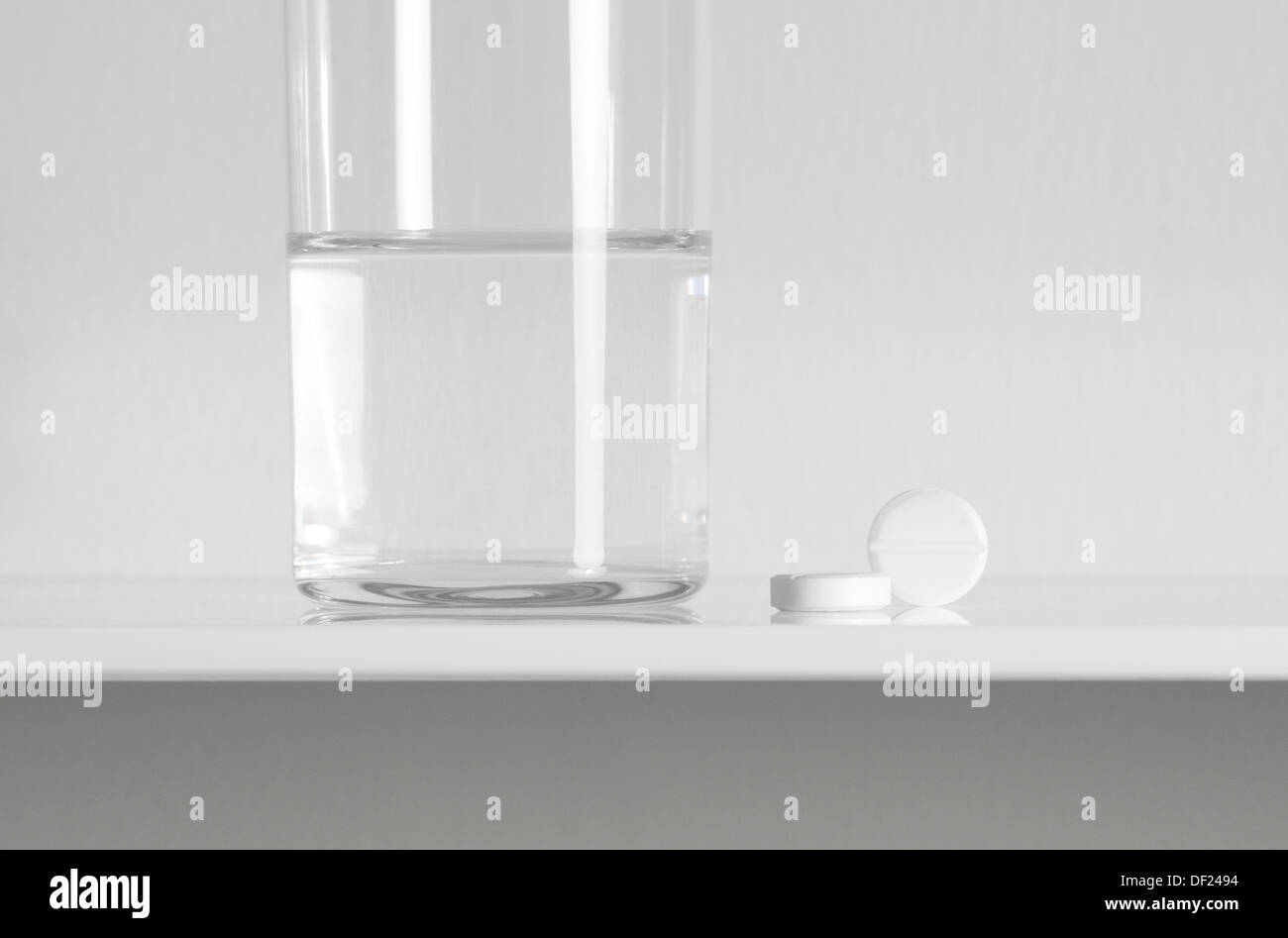 aspirin tablets and glass of water on white shelf Stock Photo Alamy