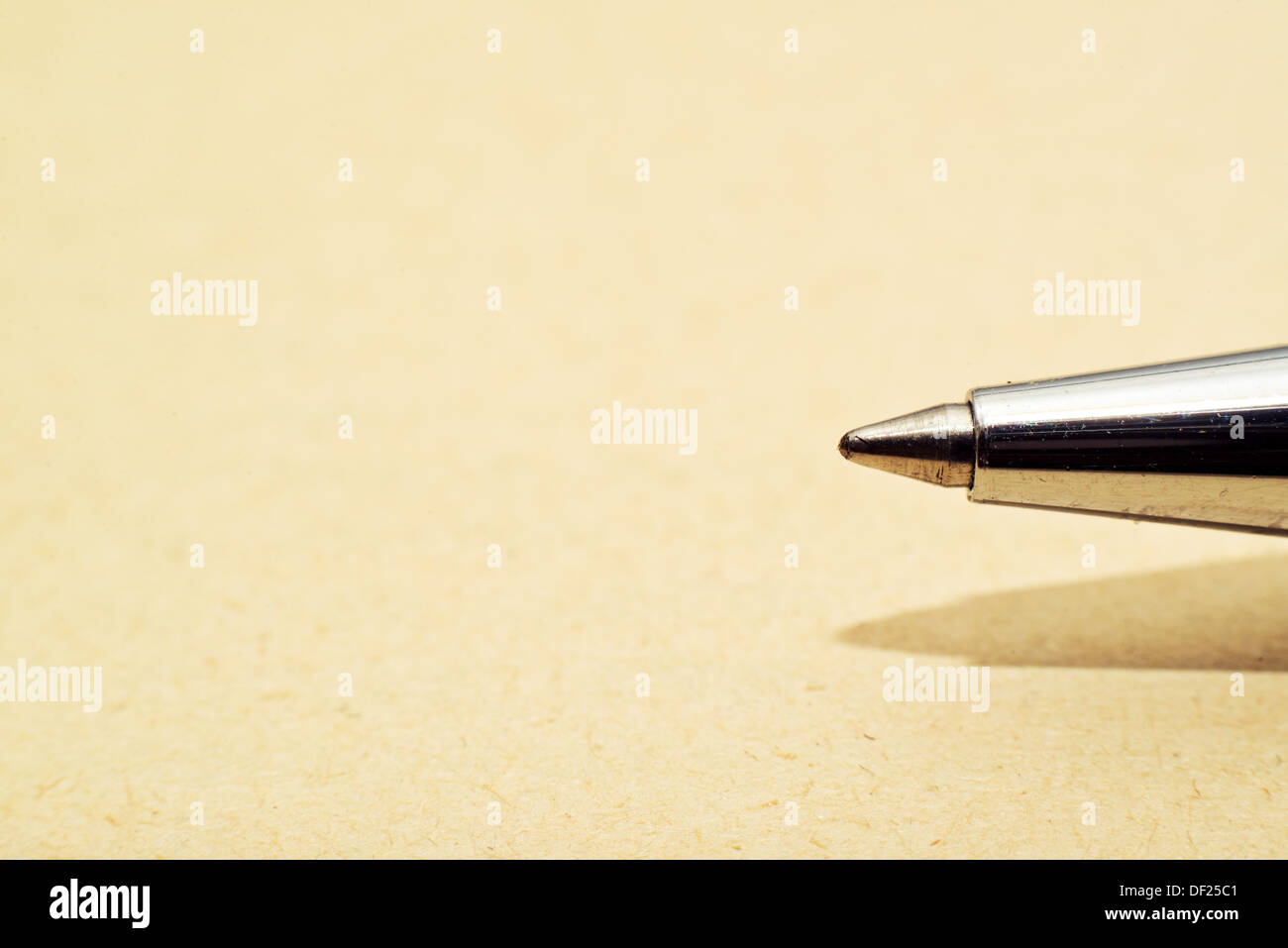 Ballpoint pen tip on yellow paper macro shot Stock Photo