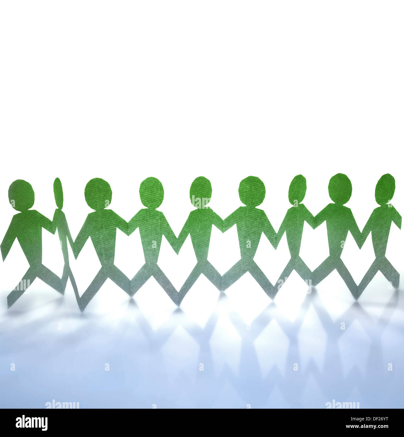 Team of paper doll people holding hands Stock Photo