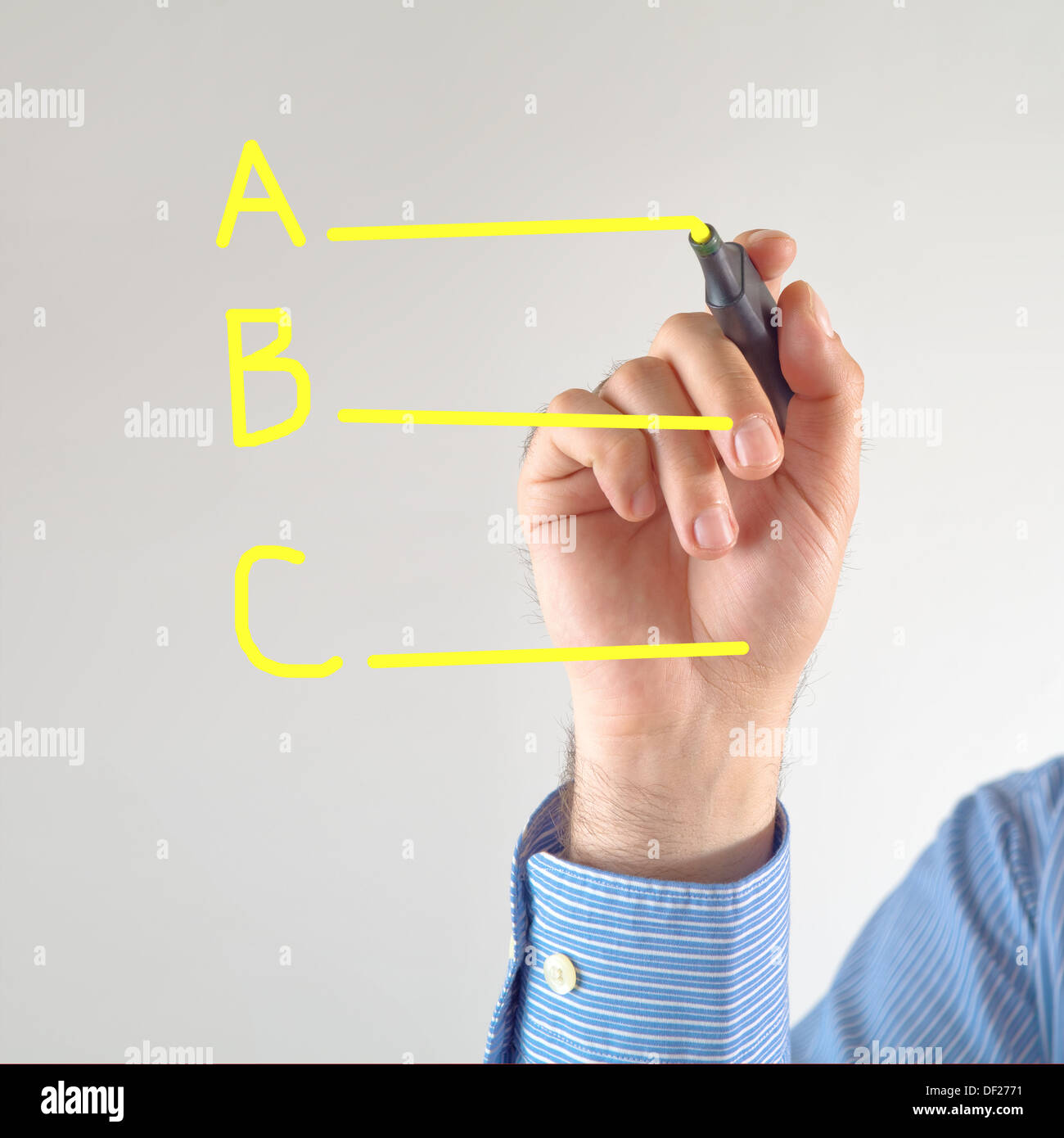 Different options. Businessman writing with yellow marker pen on the screen Stock Photo