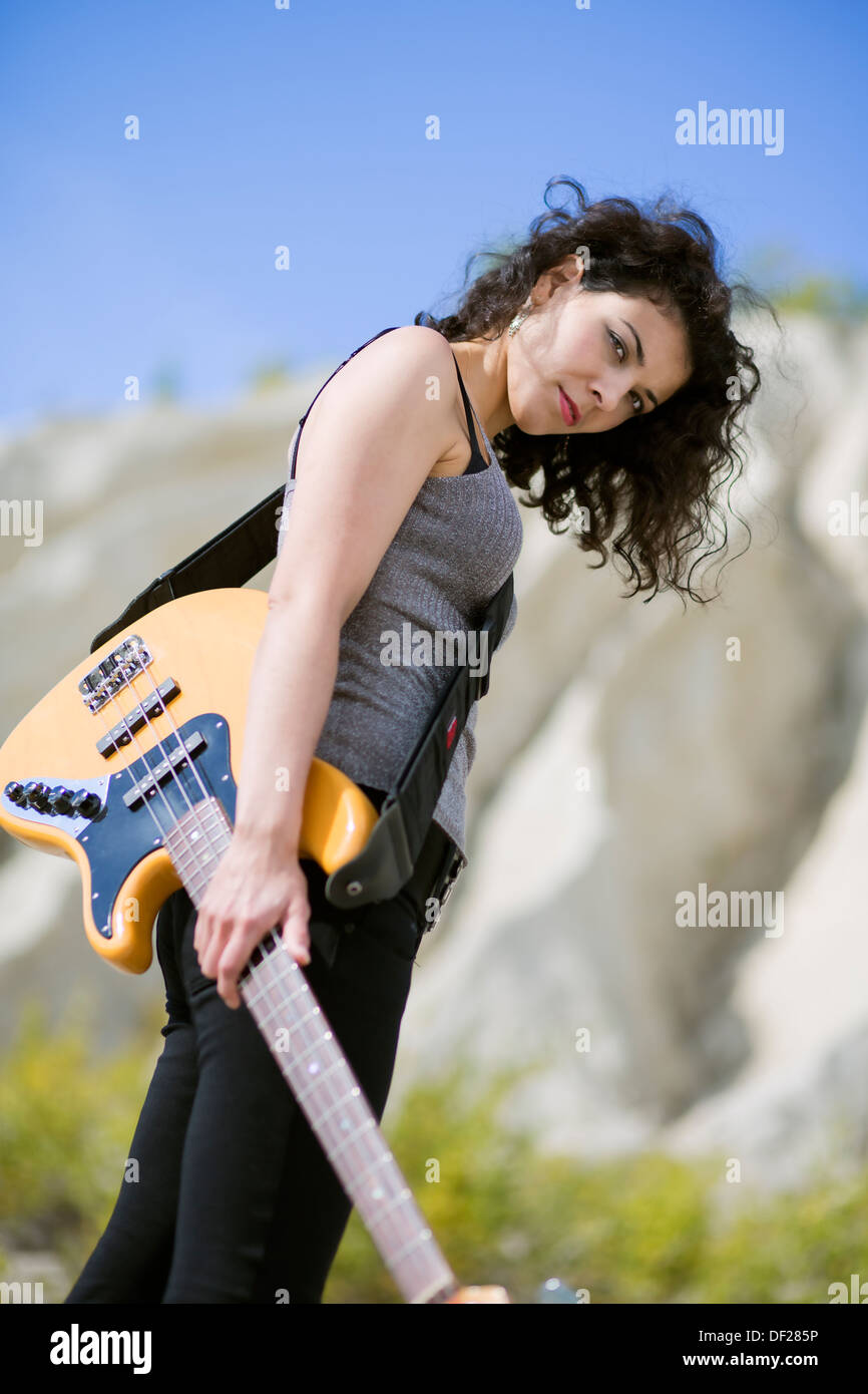 Nice looking young woman posing with yellow guitar Stock Photo