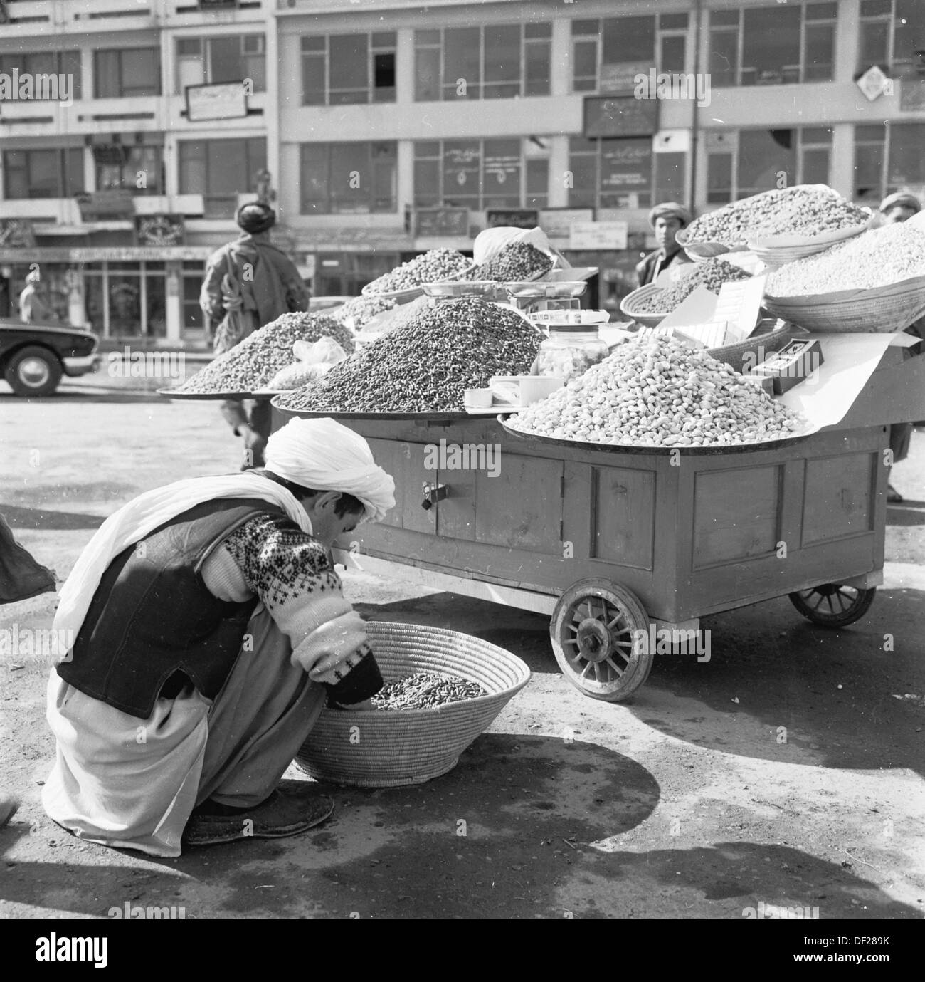 Historical picture from1950s by J Allan Cash showing an Afghan street trader in Kabul, Afghanistan preparing food for his stall. Stock Photo