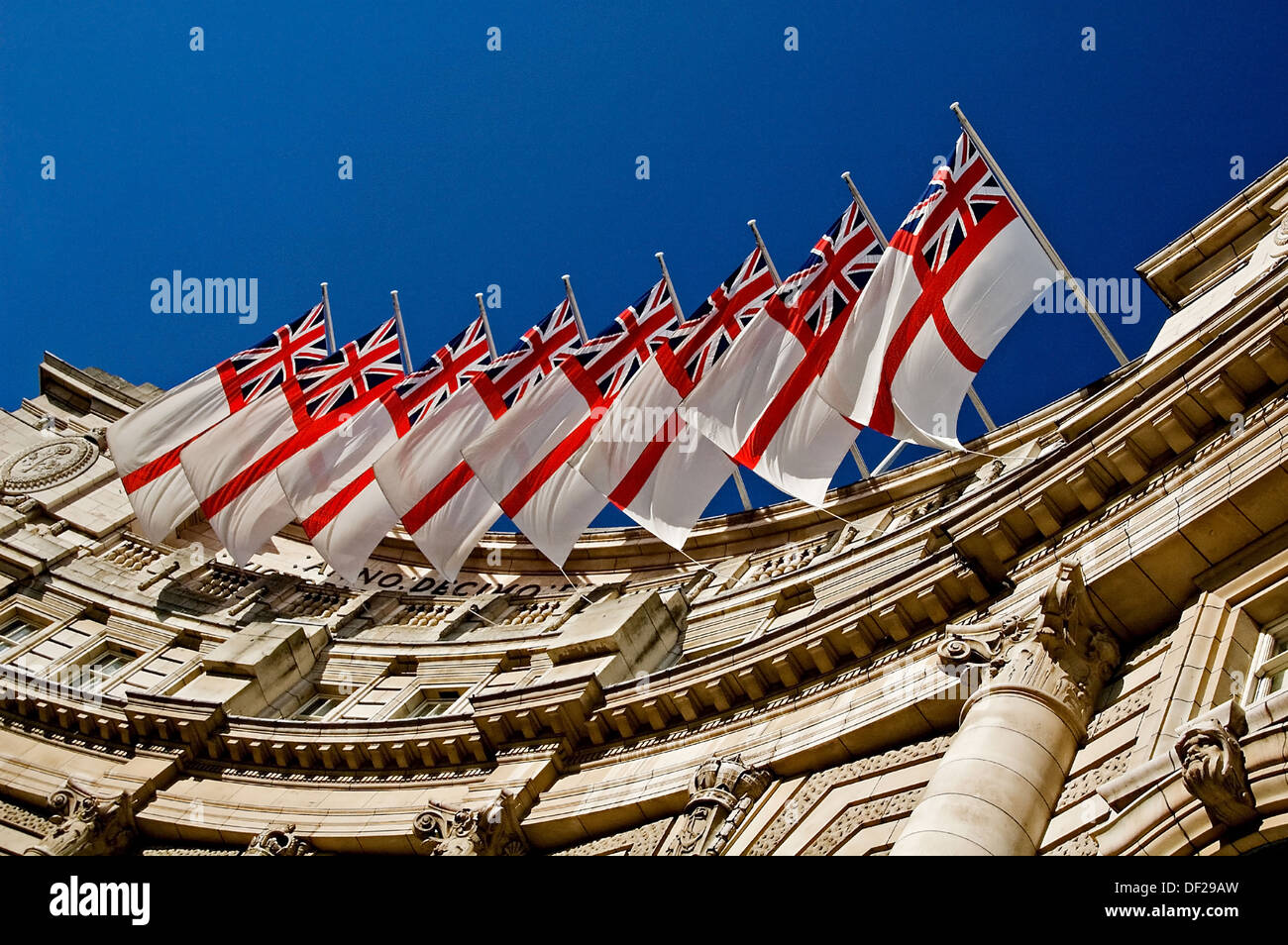 White ensign flags with the Union Jack and Cross of St George flying from Admiralty Arch, The Mall, London. Stock Photo